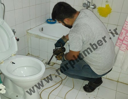 لوله بازکنی کفشور حمام با فنر برقی بدون کثیف کاری برای کفشور حمام که احتمالا با مو گرفته شده است.